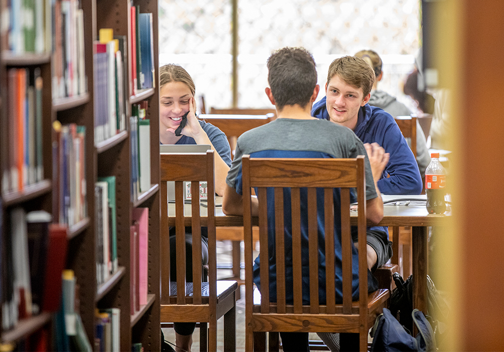 Students studying at a table in the library.